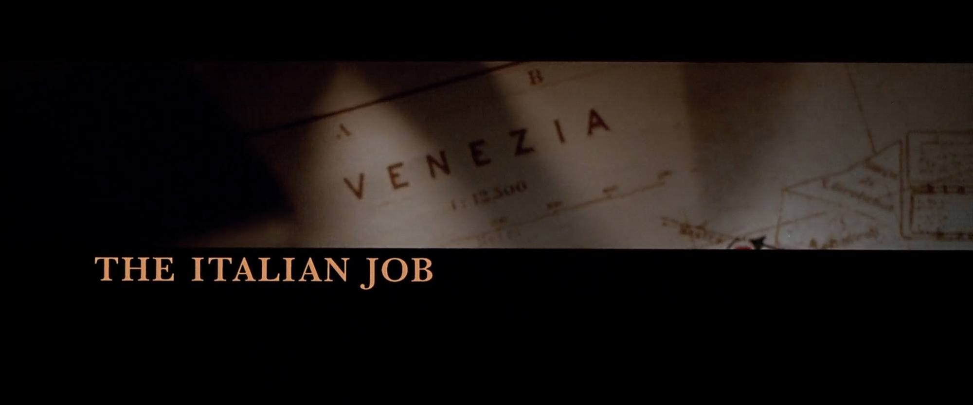 The Italian Job main title card over a hand-drawn map of Venezia