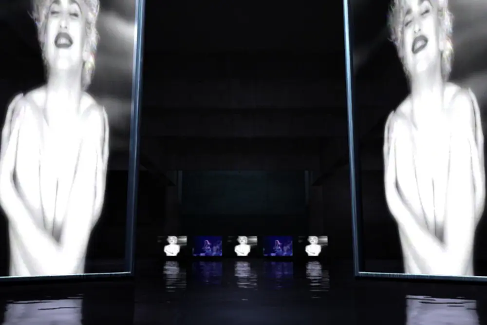 Mirrored monumental screens of Madonna flanking a dark CG hall