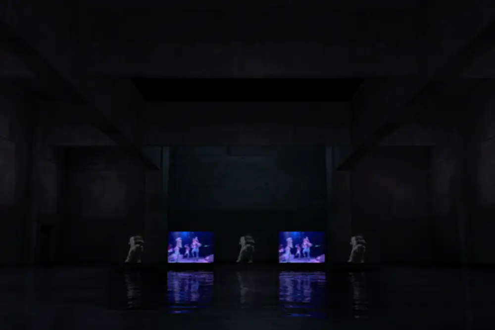 Wide view of the concrete hall with small glowing screens